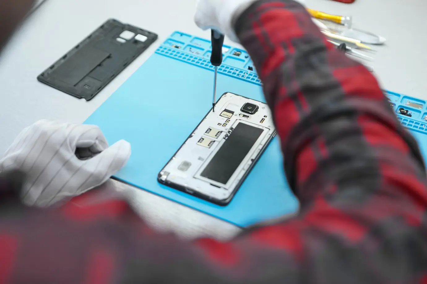 Technician carefully opening an Android smartphone